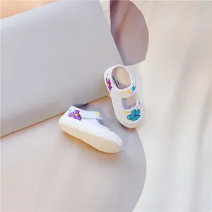 Detailansicht weißer Kinder-Segeltuchschuhe mit bunten Blumenmustern und Klettverschluss