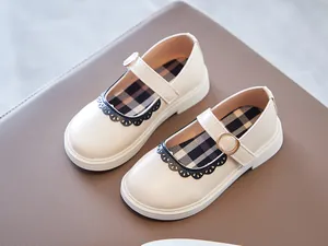 Overhead view of cream girl's Mary Jane shoes with black lace and plaid insole