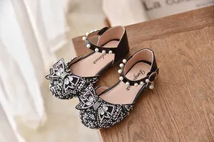 Detail van zwarte prinsessenschoenen voor meisjes met glinsterende strasstrikjes.
