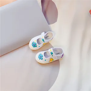 Detailansicht weißer Kinder-Canvas-Spangenschuhe mit bunten Blumenprints und Klettverschluss.