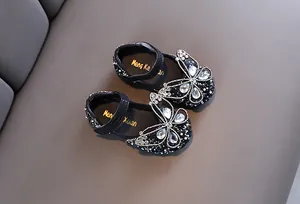 Vista detallada de zapatos de princesa negros para niñas con mariposa de diamantes