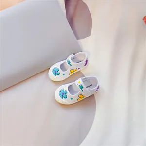 Detailansicht weißer Kinder-Segeltuchschuhe mit bunten Blumenprints und Klettverschluss
