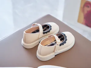 Detail view of beige Mary Jane shoes for girls with elegant scalloped lace trim