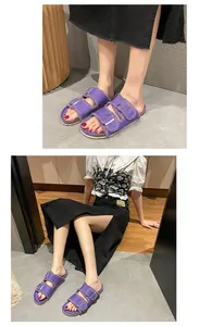 Lifestyle detail shot of purple canvas buckle sandals with frayed edges on model