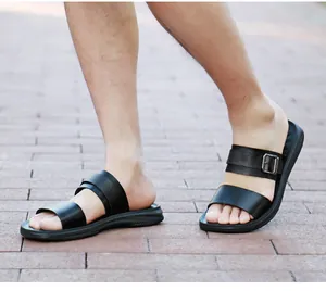 Close-up detail of men's black outdoor sandals worn on brick pavement