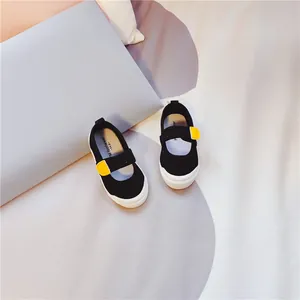 Detailaufnahme der schwarzen Kinderschuhe aus Segeltuch mit gelbem Klettverschluss.