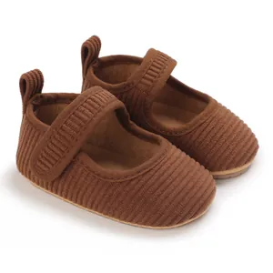 Détail des chaussures de marche bébé en velours côtelé marron avec une semelle souple