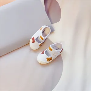 Detailansicht weißer Kinder-Stoffschuhe mit süßem Bärendruck und Klettverschluss