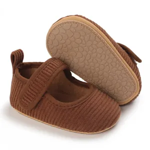 Détail montrant la texture en velours et la semelle de ces chaussures pour bébé.