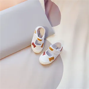 Detailansicht weißer Segeltuchschuhe für Kinder mit Bärenprint und Klettverschluss