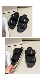 Detail view of women's black canvas flat slide sandals featuring double buckle straps and frayed edges