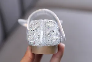 Primer plano de los brillantes diamantes de imitación y perlas en el talón de zapatos de niña