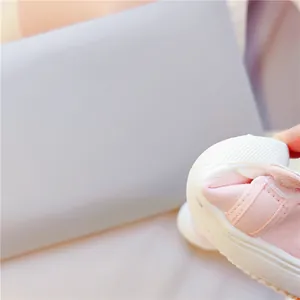 Nahaufnahme der rosa Kinder-Segeltuchschuhe mit Muschelzehen und Klettverschluss