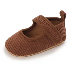Détail de chaussures de princesse en velours côtelé marron pour bébé fille avec semelle souple