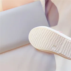 Nahaufnahme der rutschfesten Gummisohle eines weißen Kinder-Canvas-Schuhs mit Muschelzehe.