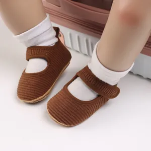 Détail de chaussures de marche bébé fille en velours côtelé marron à semelle souple