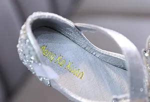 Primer plano de la plantilla de un zapato de princesa plateado con pedrería para niña