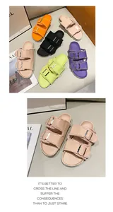 Detail view of canvas flat slippers featuring dual buckle straps and frayed denim edges.