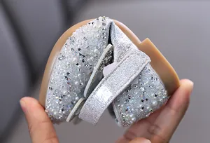 Detalle macro que muestra la flexibilidad del zapato de princesa plateado para niña