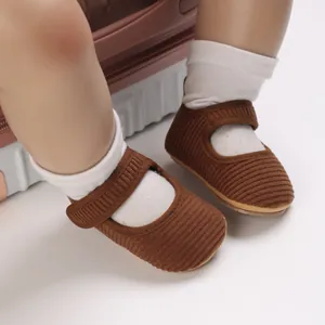 Gros plan sur la texture des chaussures de marche pour bébé fille en velours côtelé brun