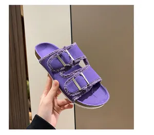 Close-up of purple canvas slide sandal with double silver buckles and raw edges