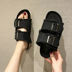 Casual women's black denim flat slides with adjustable buckle straps and frayed edges