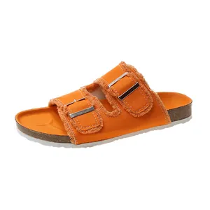 Stylish orange canvas slide sandals featuring double buckle straps and frayed edges