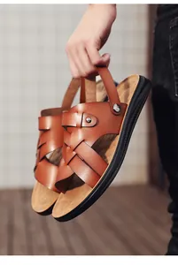Detail showing texture of brown men's leather sandals with soft anti-slip rubber soles.