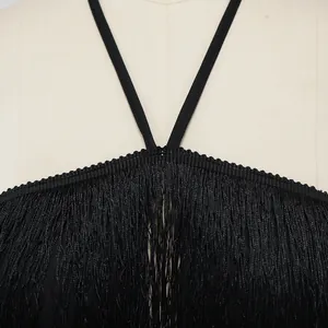 Detailed macro view showing the high-quality black fringe and halter strap on a club dress