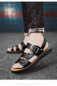 Macro view of black leather-style men's summer sandals with adjustable metal buckles.