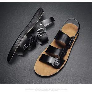 Detailed view of men's black leather sandals with tan footbed and metal buckle