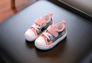 Detailed view of children's pink and checkered canvas shoes with hook-and-loop straps