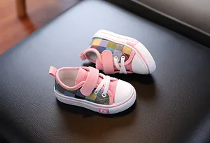 Detailed view of children's pink patchwork canvas shoes with plaid patterns.