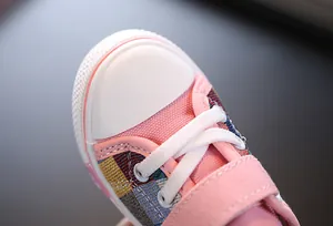 Close-up of durable white rubber toe and pink color-block canvas on kids' sneaker