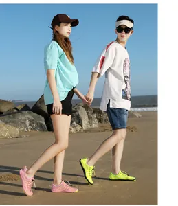Vue style de vie d'un couple portant des chaussures de plage à séchage rapide sur le sable.