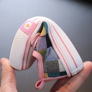 Flexible anti-slip patchwork canvas shoes for toddlers with daisy detail on heel.