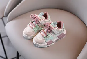 Detail der atmungsaktiven Mesh-Kinderschuhe in pastellrosa und grünen Akzenten.