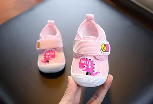 Gros plan détaillé de chaussures de marche roses pour bébé avec un motif de dinosaure