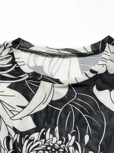 Close-up detail of the crew neckline on a black and white floral print mesh top