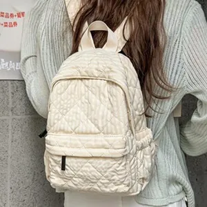 Vista trasera de mujer con mochila acolchada crema con diseño de rejilla de burbujas