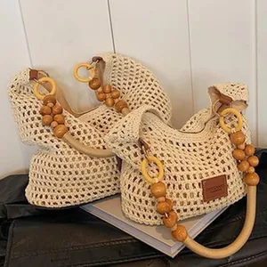Primer plano del elegante bolso de crochet con asas decorativas de cuentas de madera