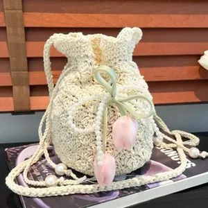 Primer plano de un bolso de ganchillo con correa de perlas y colgantes de tulipán rosa