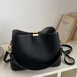 Vista detallada de un bolso de hombro negro para mujer con herrajes dorados