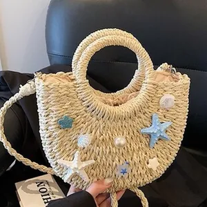 Primer plano de un bolso de paja trenzado con adornos de estrellas de mar y conchas de mar.