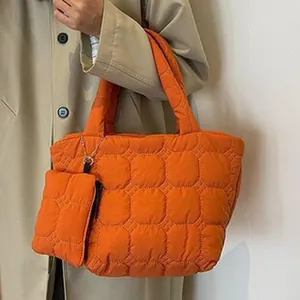 Detalle de un bolso tote acolchado de color naranja brillante con bolsa a juego