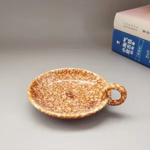 Gros plan d'un bougeoir moderne en céramique avec glaçure tachetée marron et poignée