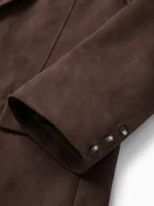 Détail du poignet d'un blazer en daim marron avec trois boutons décoratifs classiques