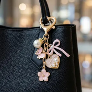 Nahaufnahme eines rosa Perlenanhängers mit Schmetterling und Herz an einer Tasche