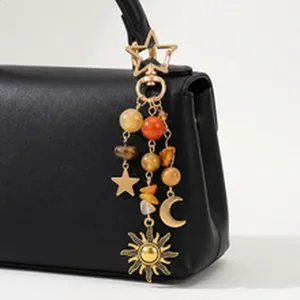 Himmlischer Taschenanhänger mit goldenen Sonnen-, Mond- und Sternanhängern am Riemen