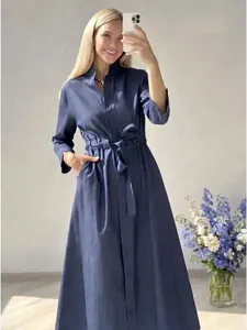 Full body view of a stylish long navy blue denim dress featuring a flattering waist tie